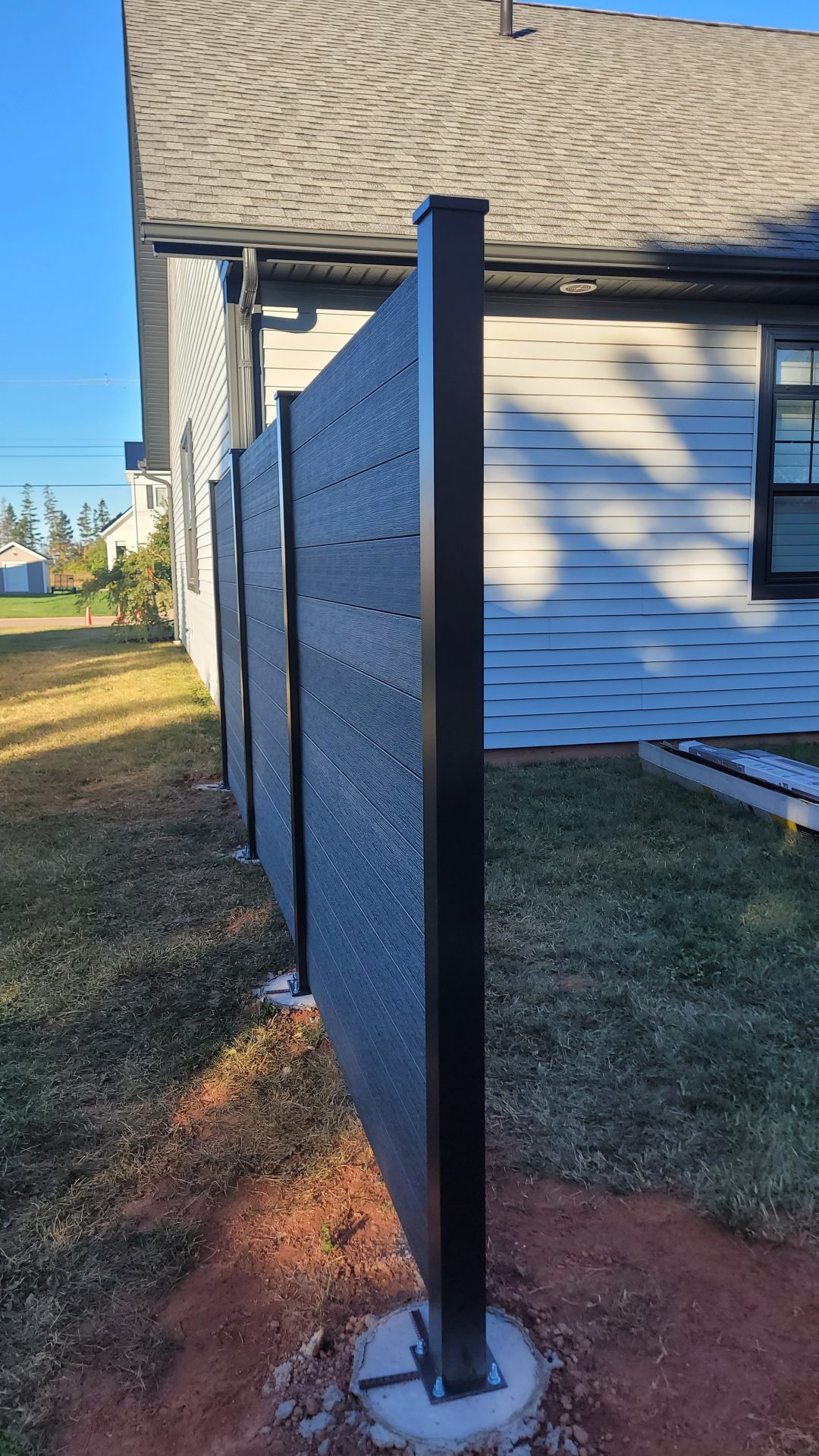 Modern privacy fence beside house exterior