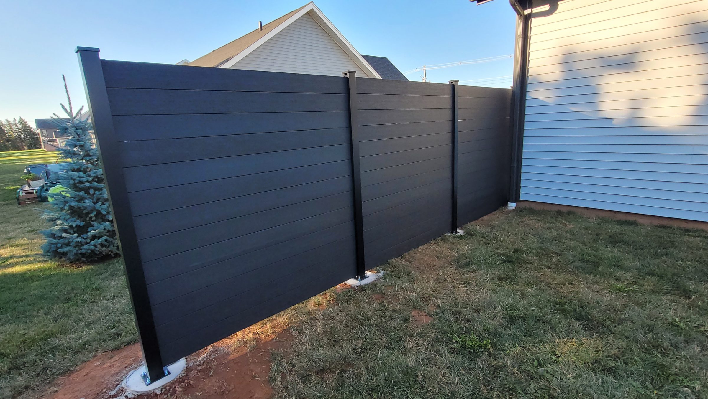 Modern black privacy fence beside house