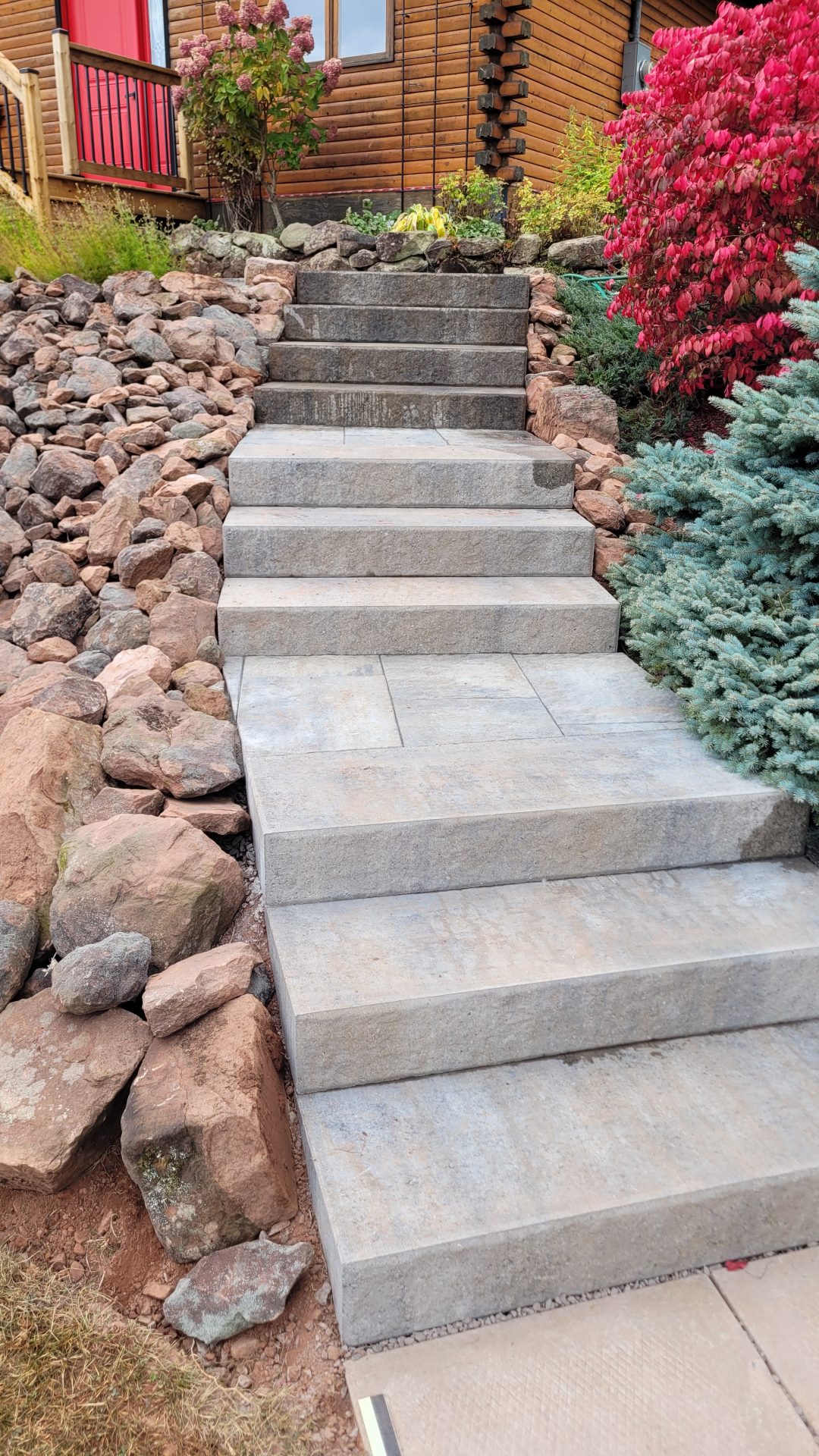 Concrete steps with colorful plants and rocks.