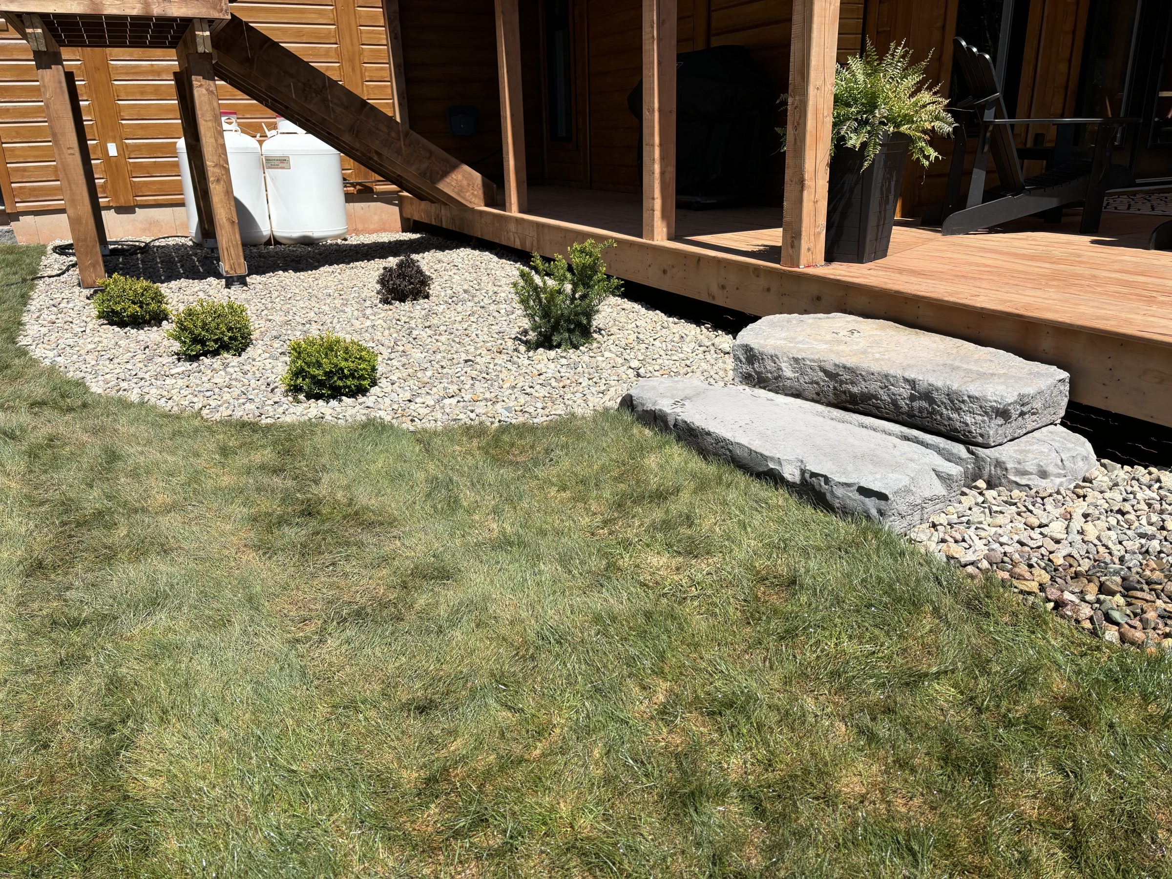 Wooden deck with stone steps and garden landscaping
