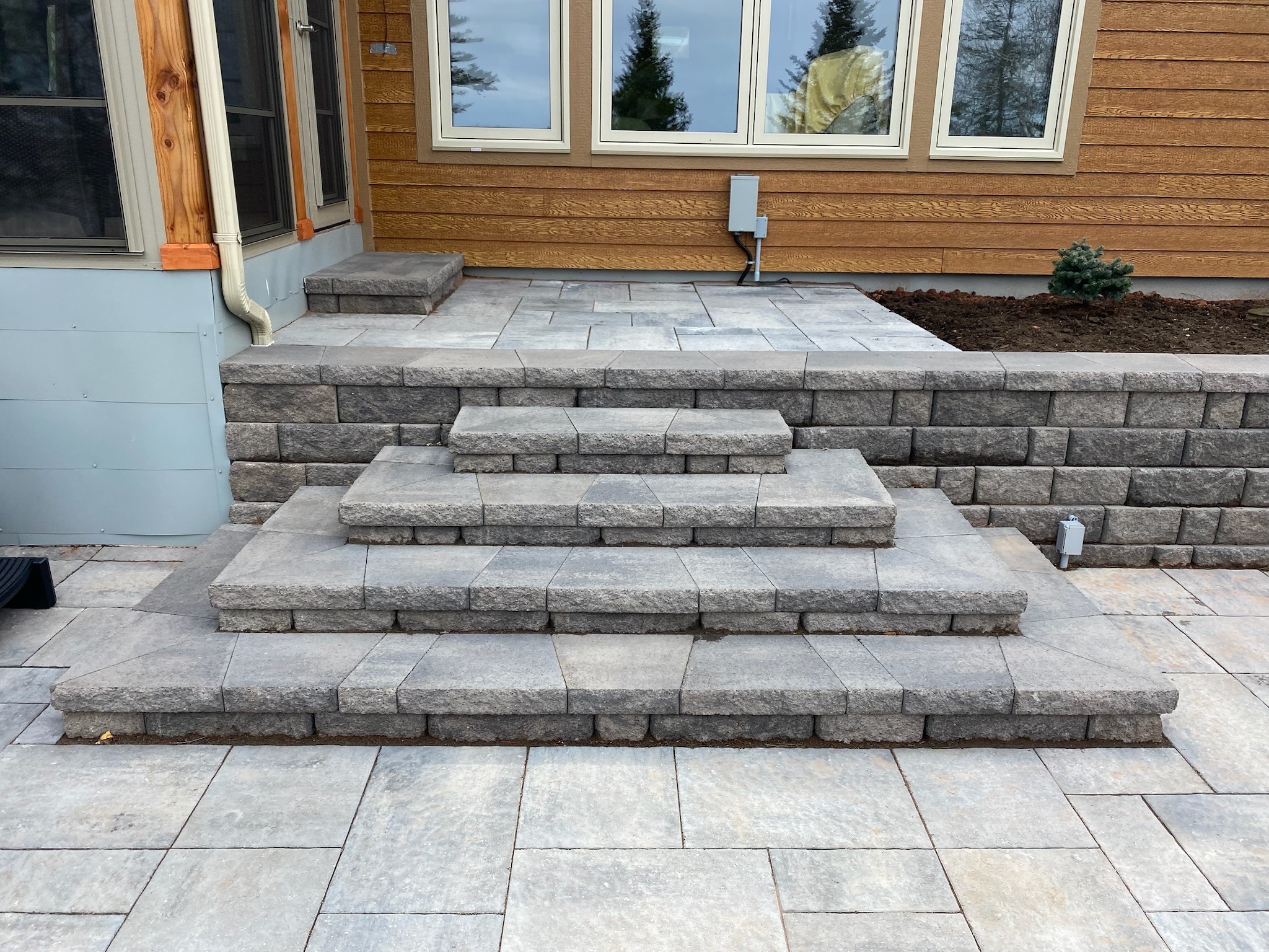 Gray stone patio steps to a house.