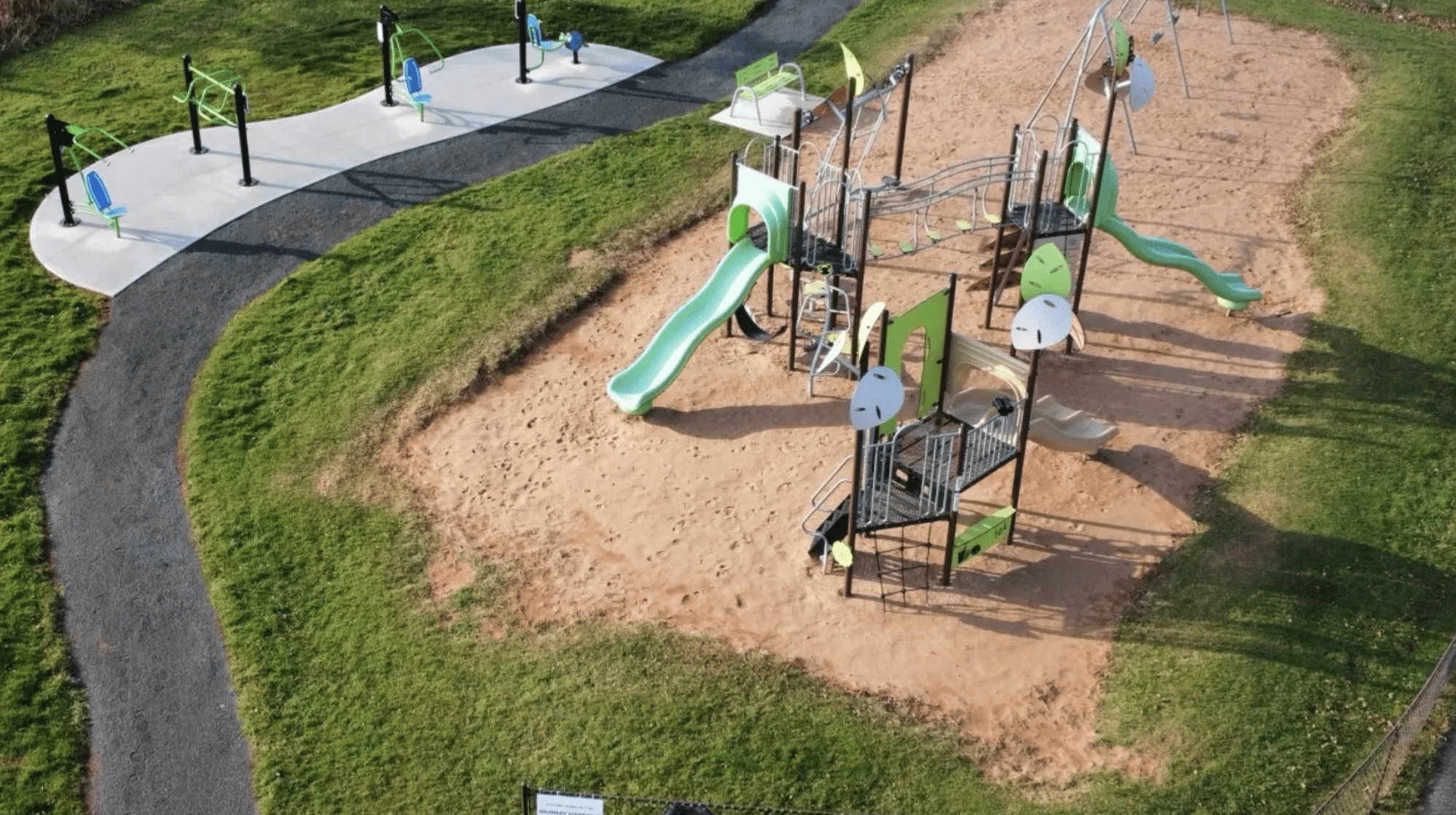 Playground with green slides and fitness equipment.