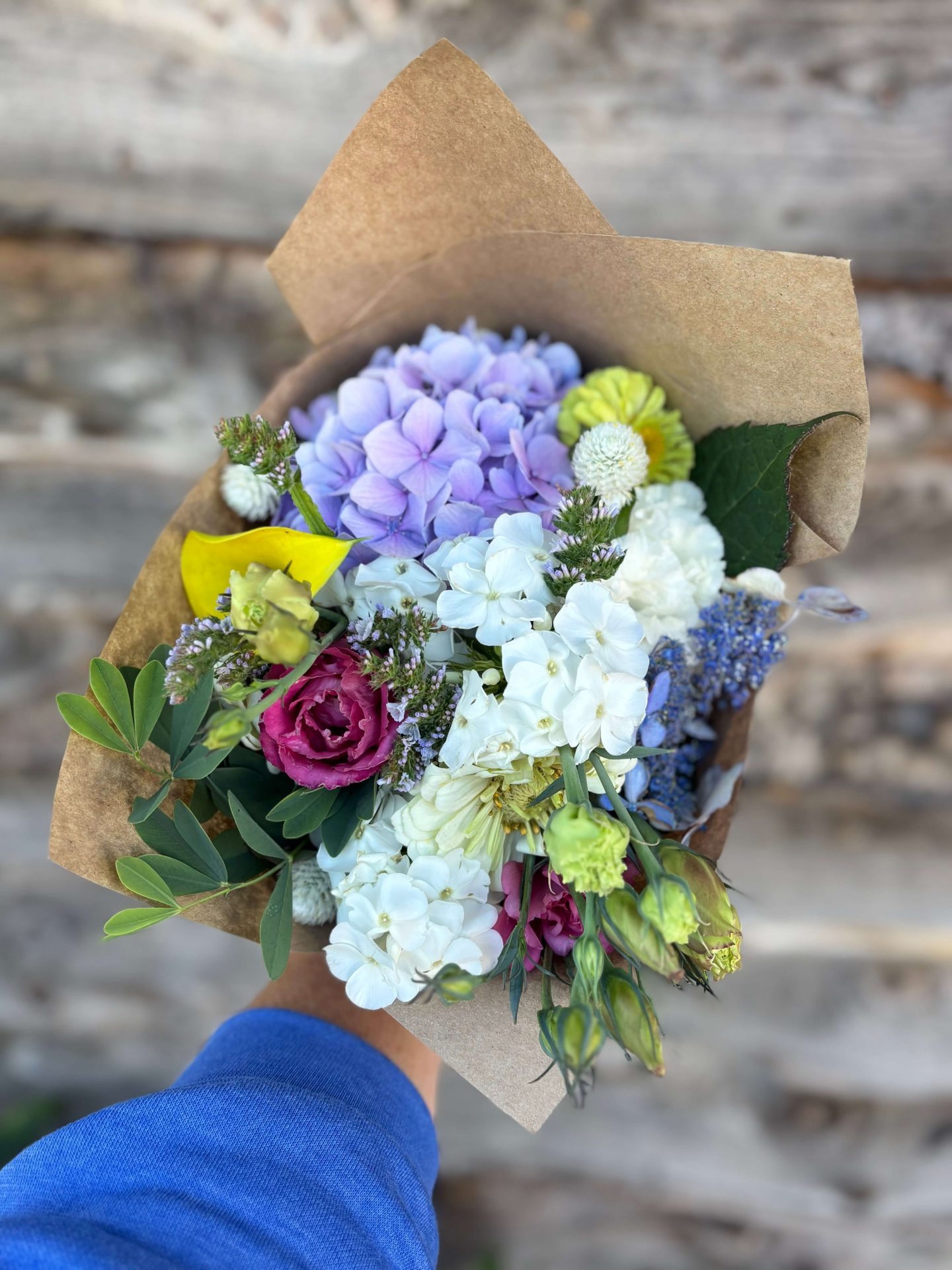 Colorful bouquet of mixed flowers against wooden background.
