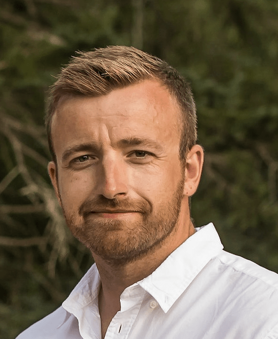 Smiling man outdoors in white shirt