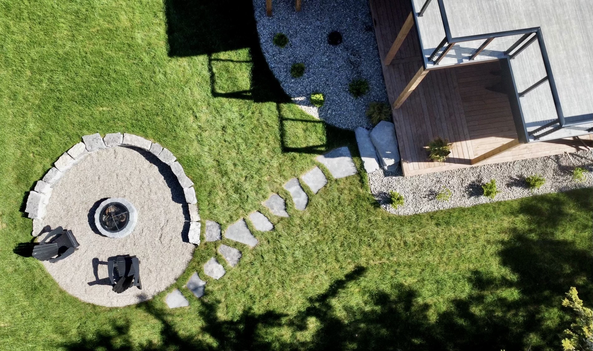 Aerial view of fire pit with chairs and path.