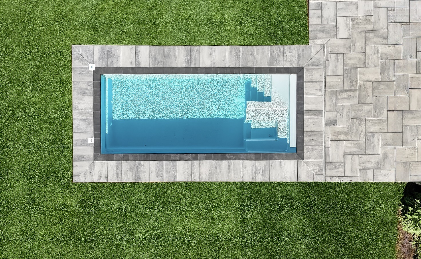Rectangular pool with patio and grass surroundings.