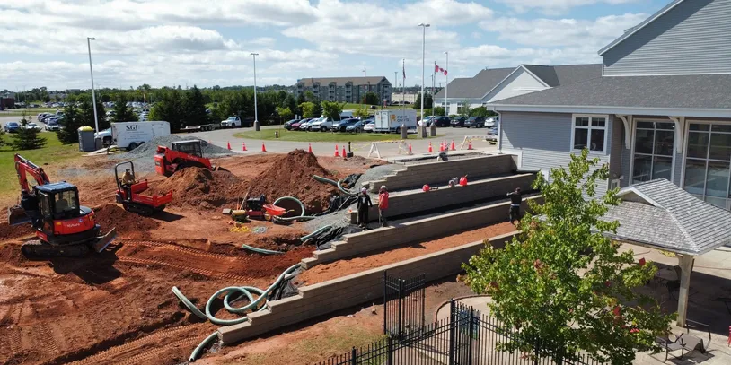 Construction site with heavy machinery near a building.